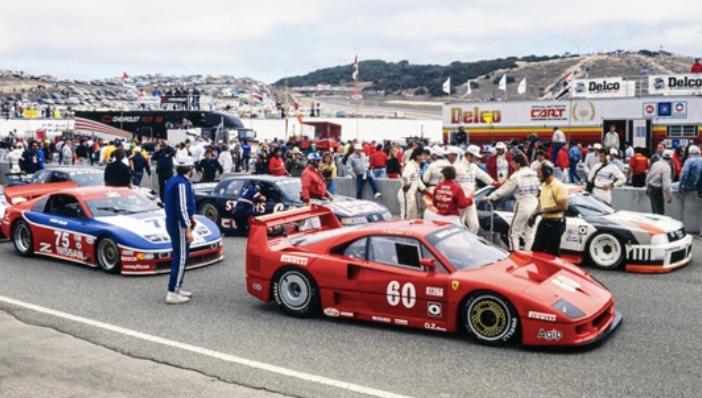Ferrari F40 Competizione numero 60 rossa nel paddock della gara IMSA con altre vetture da corsa