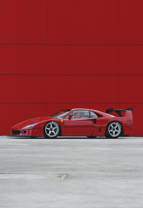 Ferrari F40 Competizione rossa di profilo su sfondo rosso
